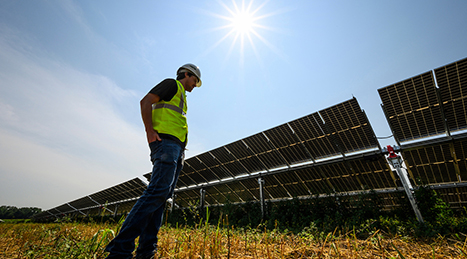 John Armstrong, a project manager with Madison Gas and Electric and 2012 alumnus of UW-Madison, stands as the sun shines down on a silhouetted row of solar panels at Madison Gas and Electric’s (MGE) O’Brien Solar Fields in Fitchburg, Wis., during summer on July 27, 2021. The 140-acre solar field includes 60,318 bifacial panels capable of generating approximately 20 megawatts of renewable electricity. The project is a collaborative partnership with the University of Wisconsin-Madison and a range of businesses and agencies under the aegis of MGE’s Renewable Energy Rider. (Photo by Jeff Miller/UW-Madison)
