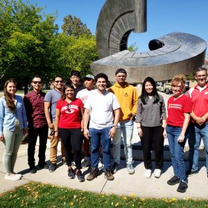 Dr. George W. Huber's research group outdoors near the sculpture on UW–Madison's Engineering campus, in 2021.