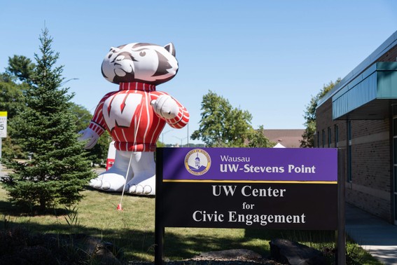 A tall Bucky stands next to a sign for the Wausau UW-Stevens Point UW Center for Civic Engagement