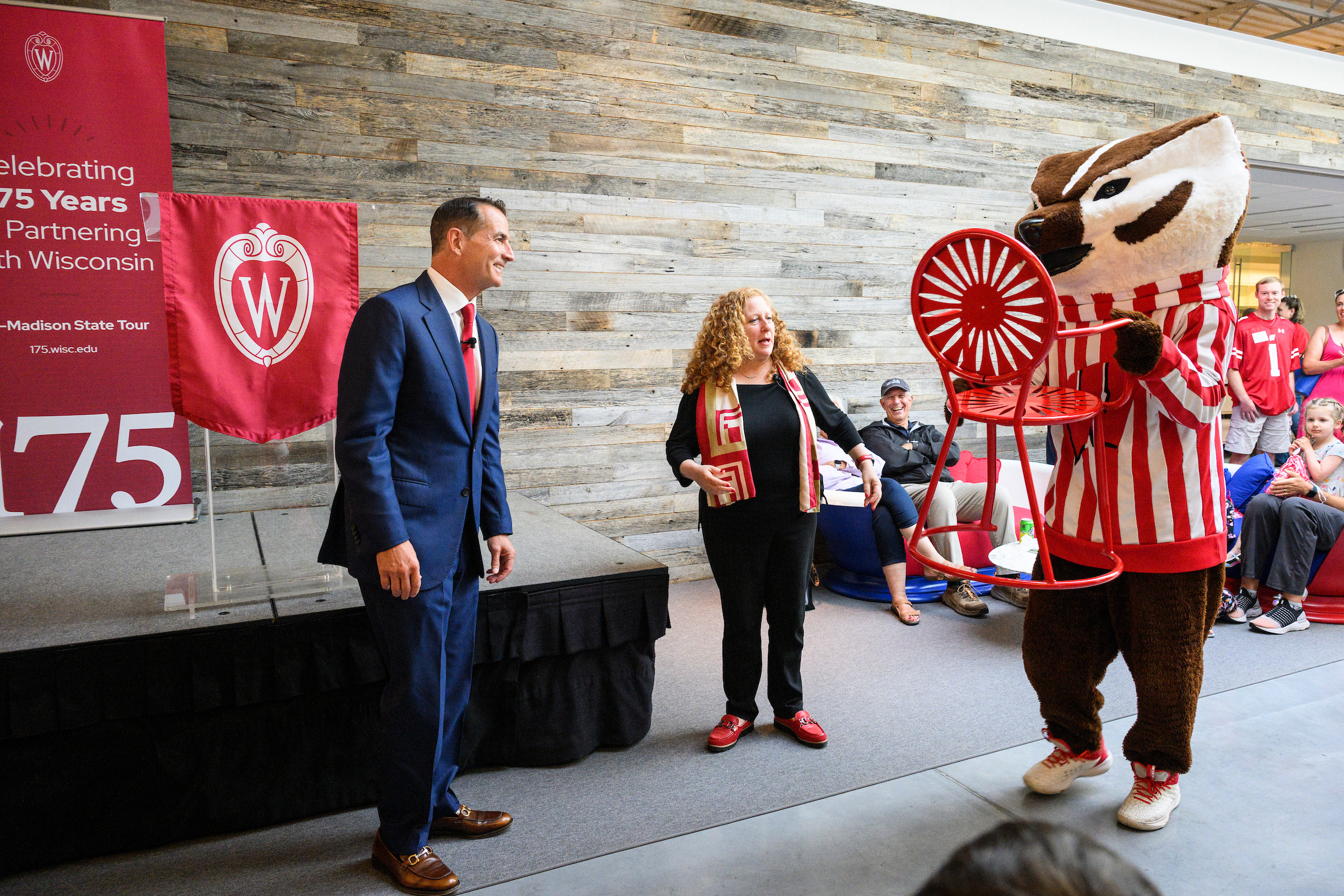 Bucky Badger and Chancellor Jennifer Mnookin present a terrace chair with the iconic starburst design to David Kohler, chair and chief executive officer of Kohler Co., during a Wisconsin Foundation and Alumni Association Community Celebration, a family-friendly event including ice cream, yard games, and a visit from Bucky Badger held at Kohler Communications in Kohler, Wisconsin on June 28, 2023. The event is part of a day-long celebration in Sheboygan, Wisconsin to kick-off the 175-year anniversary of the University of Wisconsin and to highlight the strong ties between the community and Wisconsin’s flagship university. 