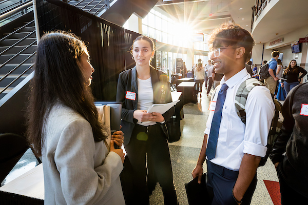 Friends (from left to right) Ananya Guruprasad, Erica Henderson, and Harsh Kadodwala stop to talk during the fall Career and Internship Fair at the Kohl Center at the University of Wisconsin-Madison on Sept. 20, 2023. (Photo by Taylor Wolfram / UW–Madison)
