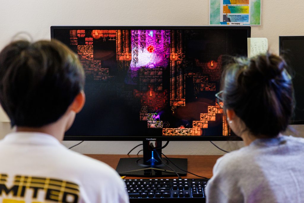 Students designing a game look at a computer screen
