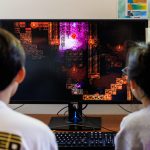 Students designing a game look at a computer screen