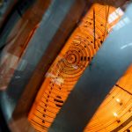 View through metal supports into the glowing orange cylindrical interior of UW–Madison’s Big Red Ball fusion experiment.