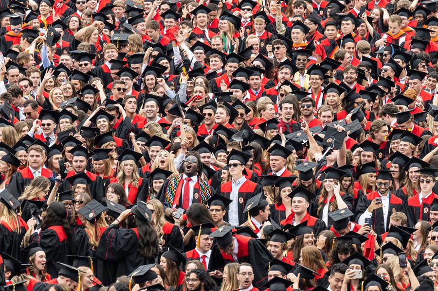 Photo of crowd of graduates in caps and gowns.