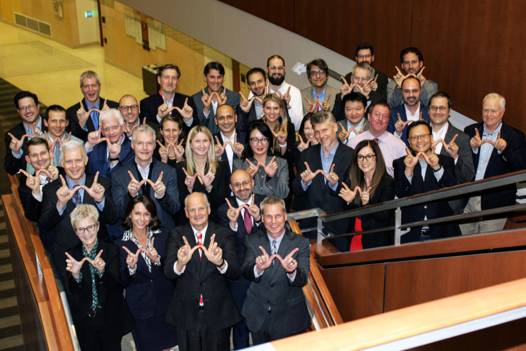 Colleagues from UW–Madison and GE HealthCare give the W sign in celebration of the next ten years of strategic collaboration.