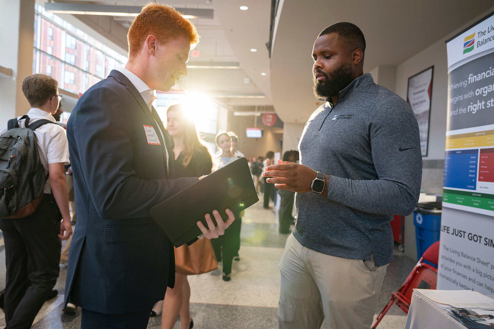 A student speaks to a recruiter at the Kohl Center during a career fair.