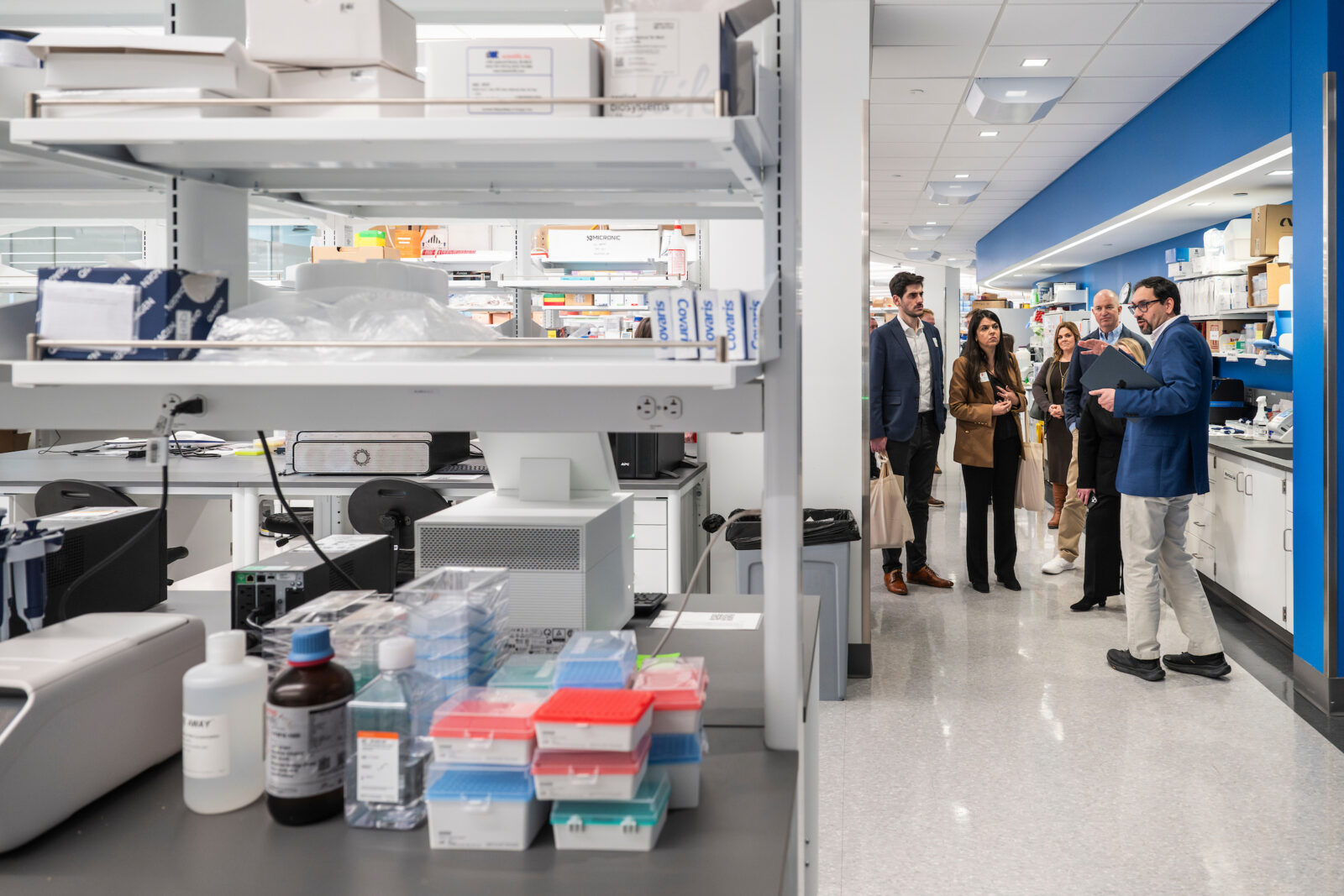 A group of people take a tour of a medical lab.
