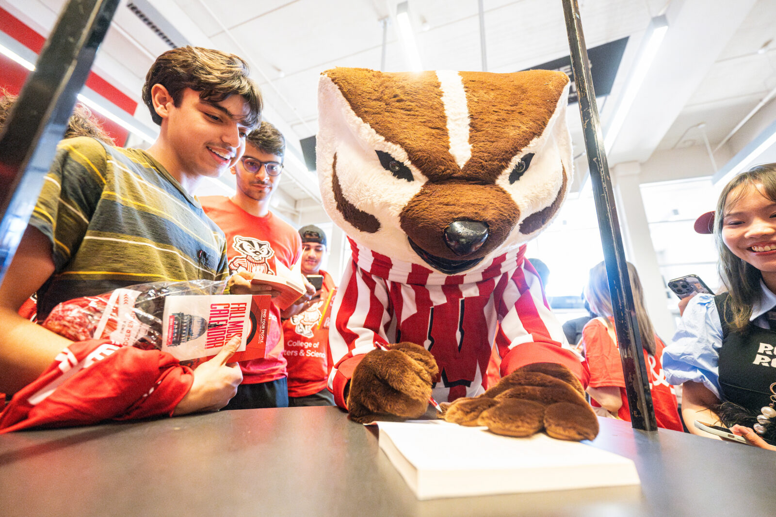 UW mascot Bucky Badger signs a book