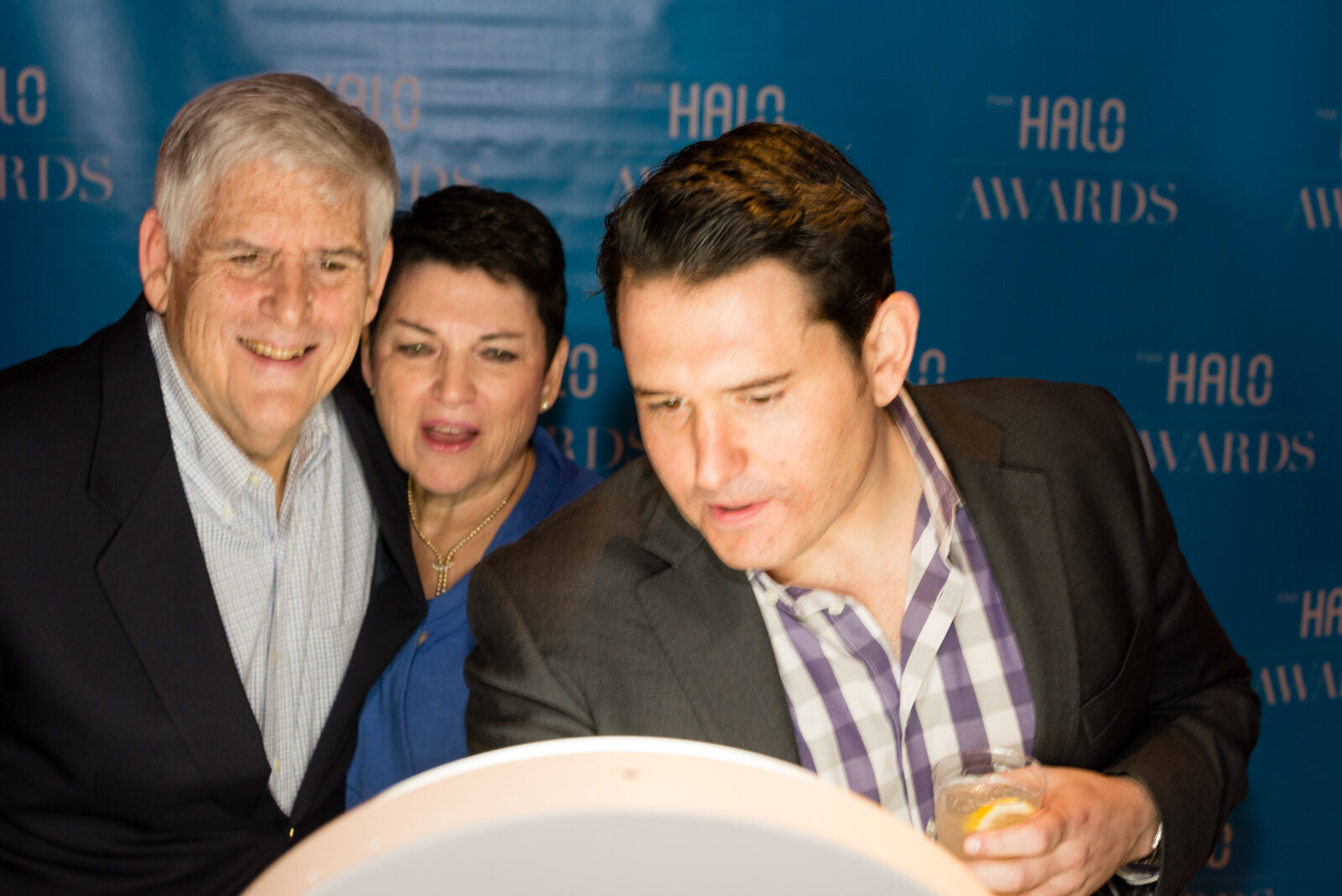 Three people look at a glowing screen.