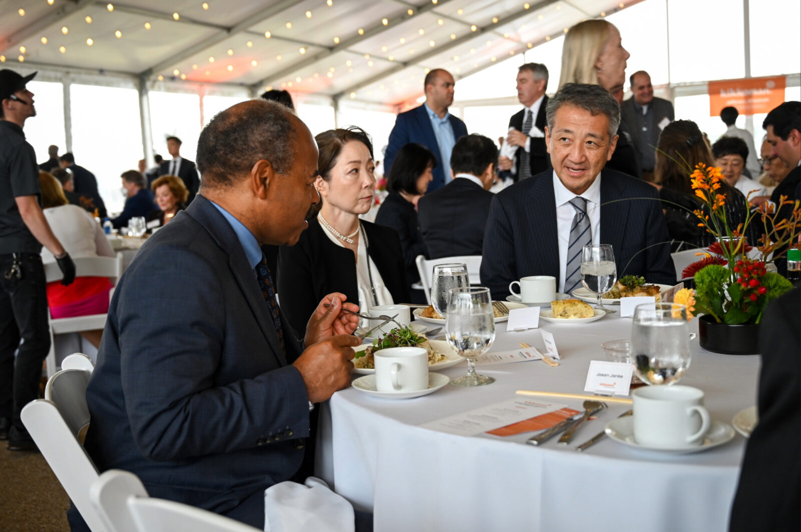 Eric Wilcots sits at a luncheon table talking with other guests.